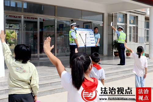 9月22日，枣庄市公安局山亭分局交警大队民辅警在东江湖小学利用宣传画教学生们练习交通指挥手势。.jpg