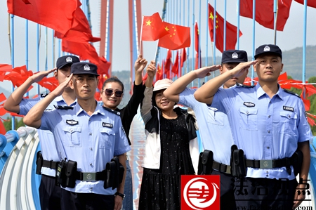 9月30日，枣庄市公安局山亭分局徐庄派出所民辅警和游客们在葫芦套景区的玻璃栈道上面对迎风飘扬的国旗，共同祝福伟大的祖国繁荣昌盛。.jpg