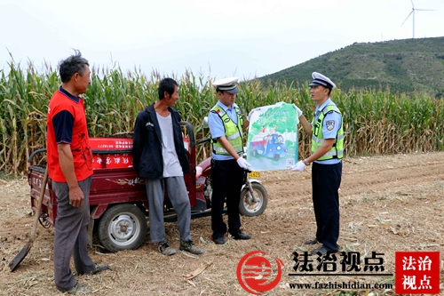 9月20日，枣庄市公安局山亭分局交警大民警在田间开展交通安全宣传活动，向忙于秋收的农民朋友宣讲安全出行知识。.jpg