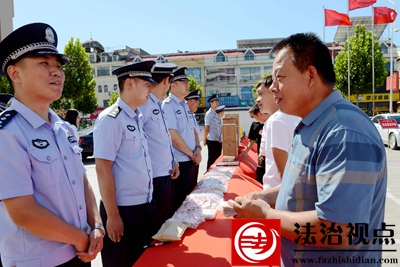 9月22日，刘姓村民从山东省枣庄市公安局山亭分局民警王贺（左一）手中领回破案追回的14000元被骗现金，脸上露出了开心笑容。.jpg