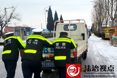 2月21日，枣庄市公安局山亭分局交警大队民辅警将受困车辆推至安全地带。1.jpg